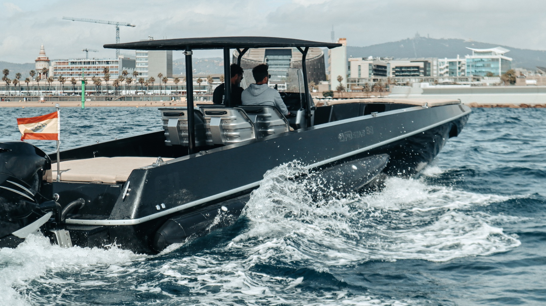 F11 running past Barcelona beachfront and Tibidabo hills