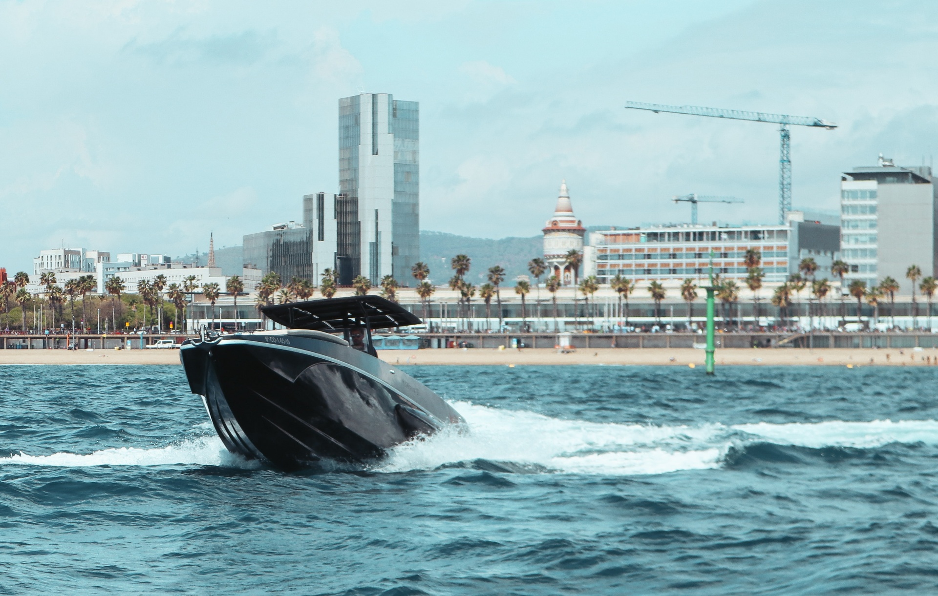 F11 charging toward camera with Barcelona Diagonal Mar behind